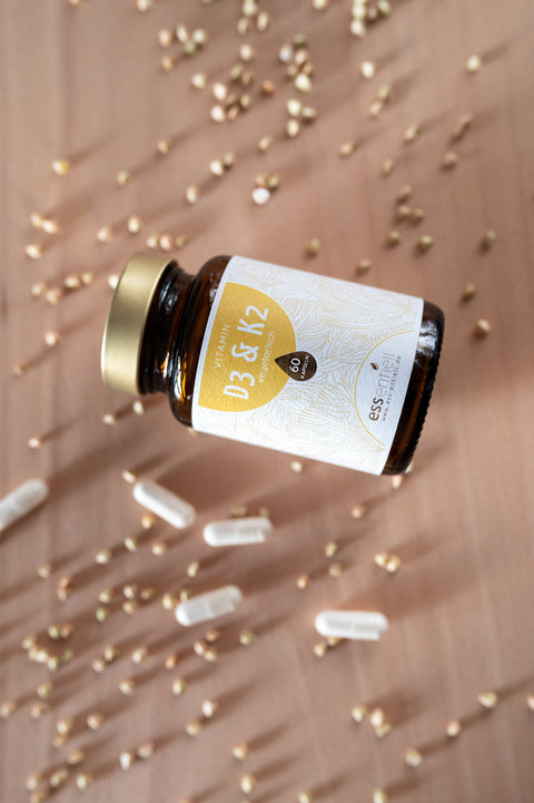 Vitamin D3 und K2 Kapseln im braunen Glas von ess-entiell auf hellem Hintergrund
